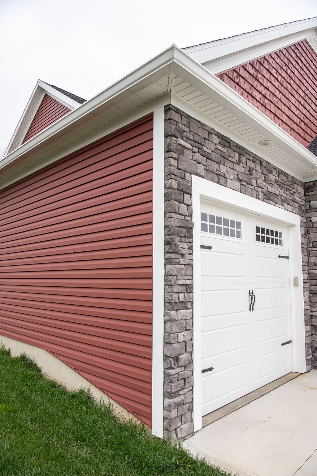 A garage with a red siding and a white garage door.