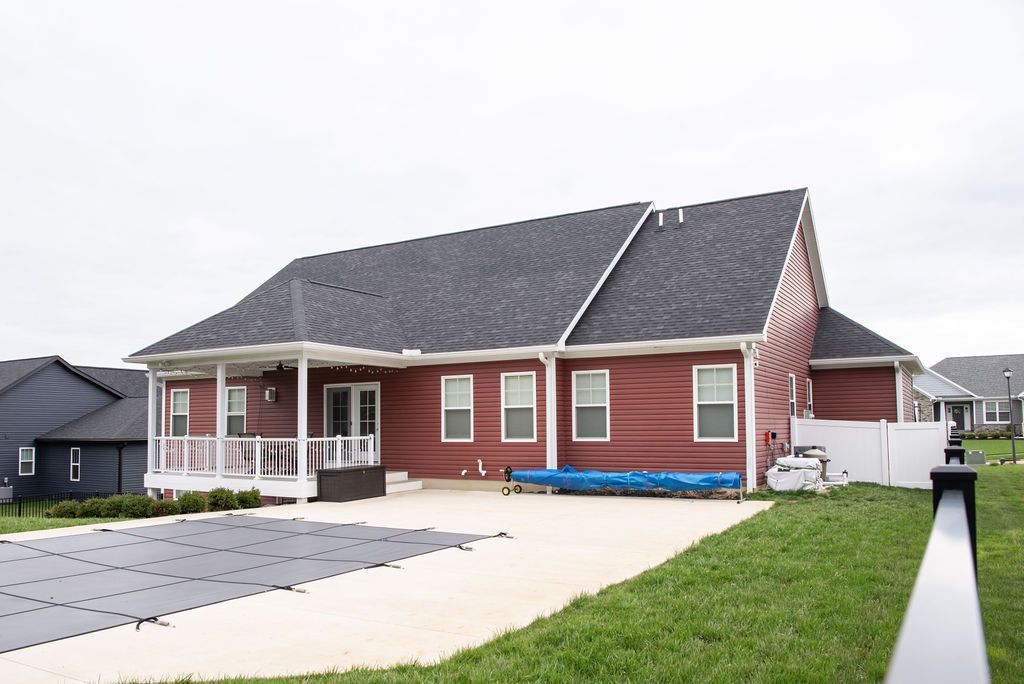 A red house with a swimming pool in front of it