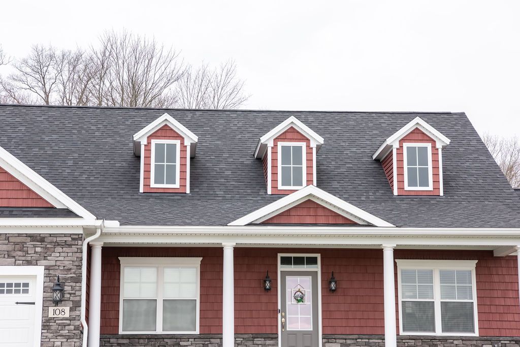 A red house with a black roof and a porch.