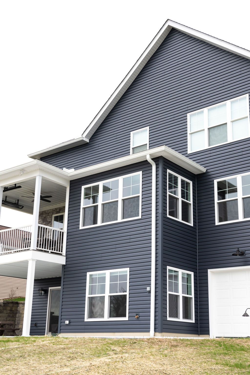 A large blue house with a lot of windows and a balcony.