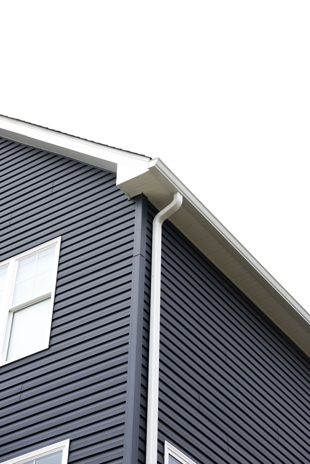 A black house with white windows and a white gutter on the side.