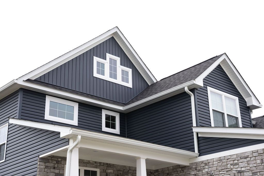 A large house with a black siding and a white roof.