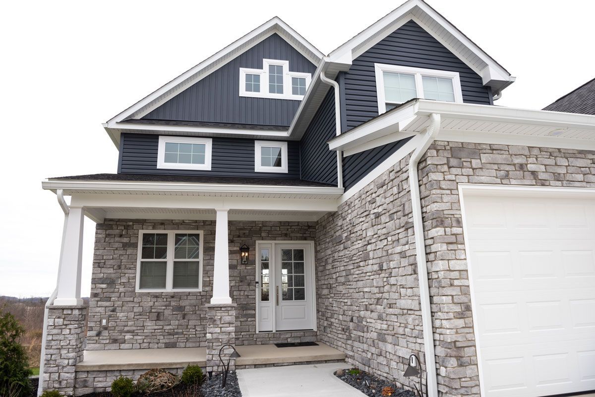 A large house with a stone facade and a white garage door.