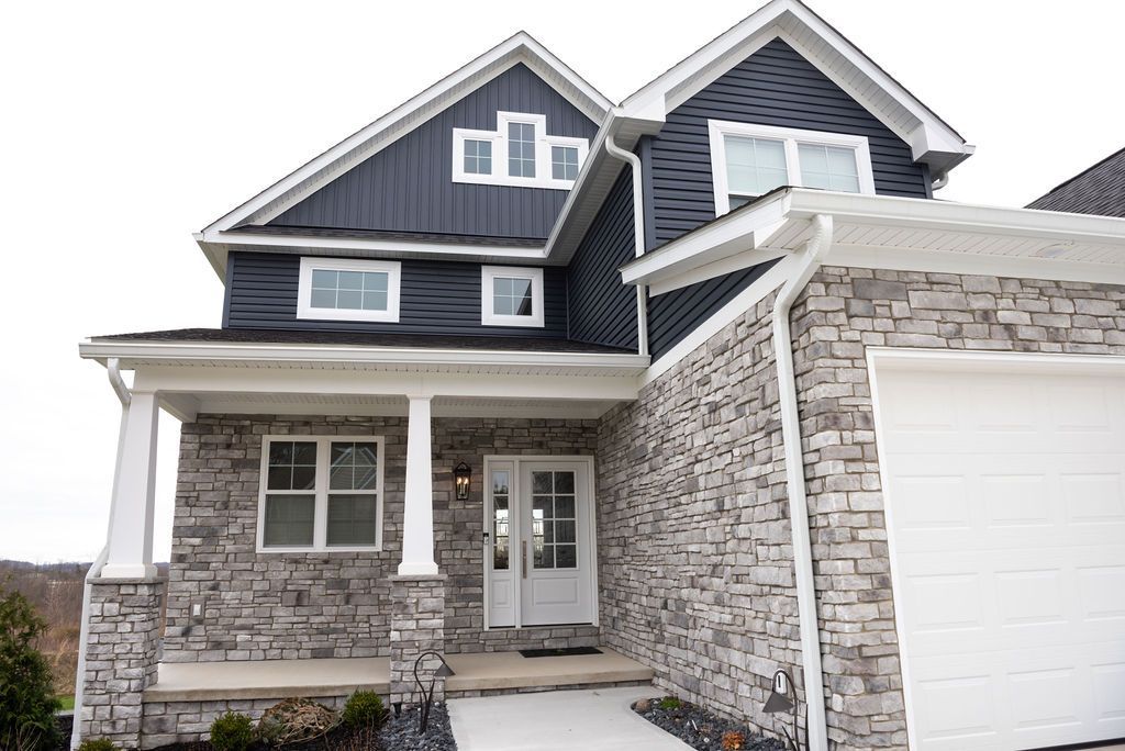 A large house with a stone facade and a white garage door.