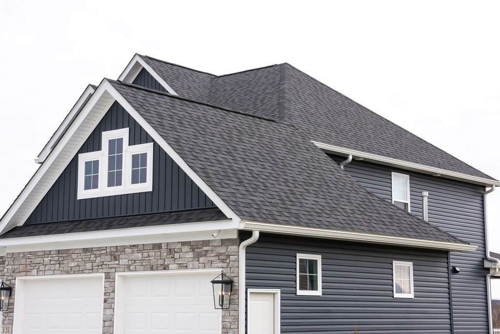 A black house with a gray roof and white trim