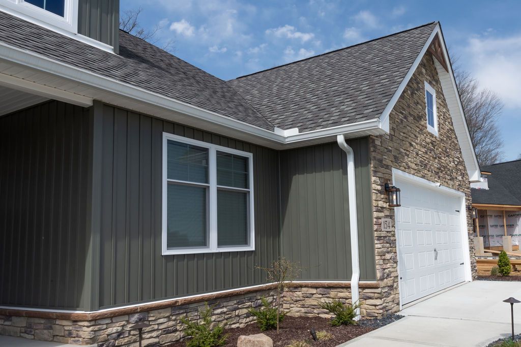 A house with a gray siding and a white garage door.