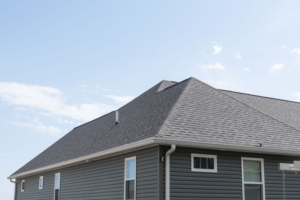 A house with a gray roof and a blue sky in the background.