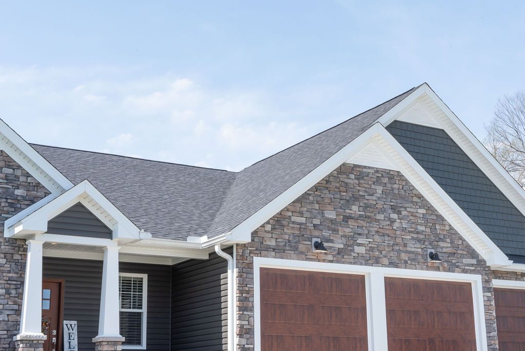 A house with a gray roof and brown garage doors.