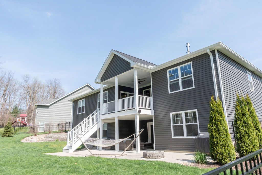 The back of a house with a large deck and stairs.