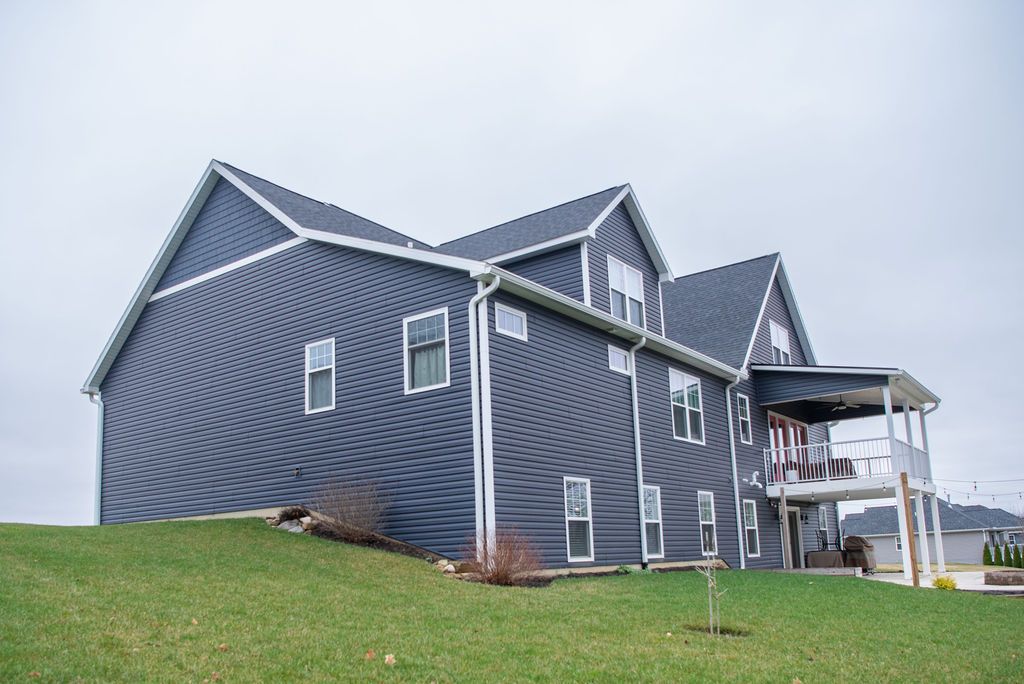 A large house is sitting on top of a grassy hill.