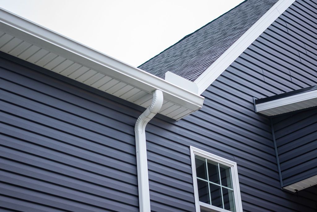 A black house with a white gutter and a window