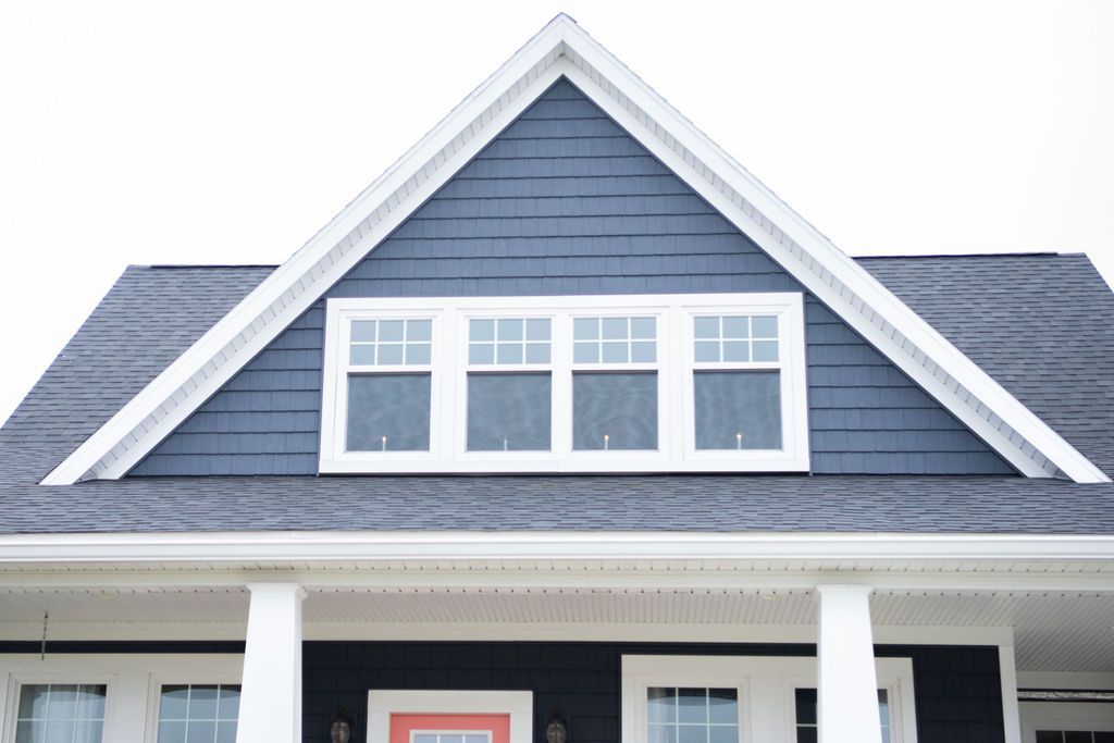 A blue house with a white trim and a red door