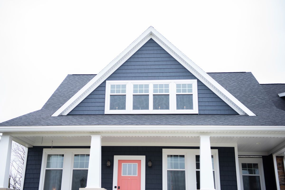 A blue house with a red door and white trim