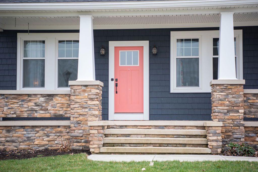 A blue house with a red door and steps