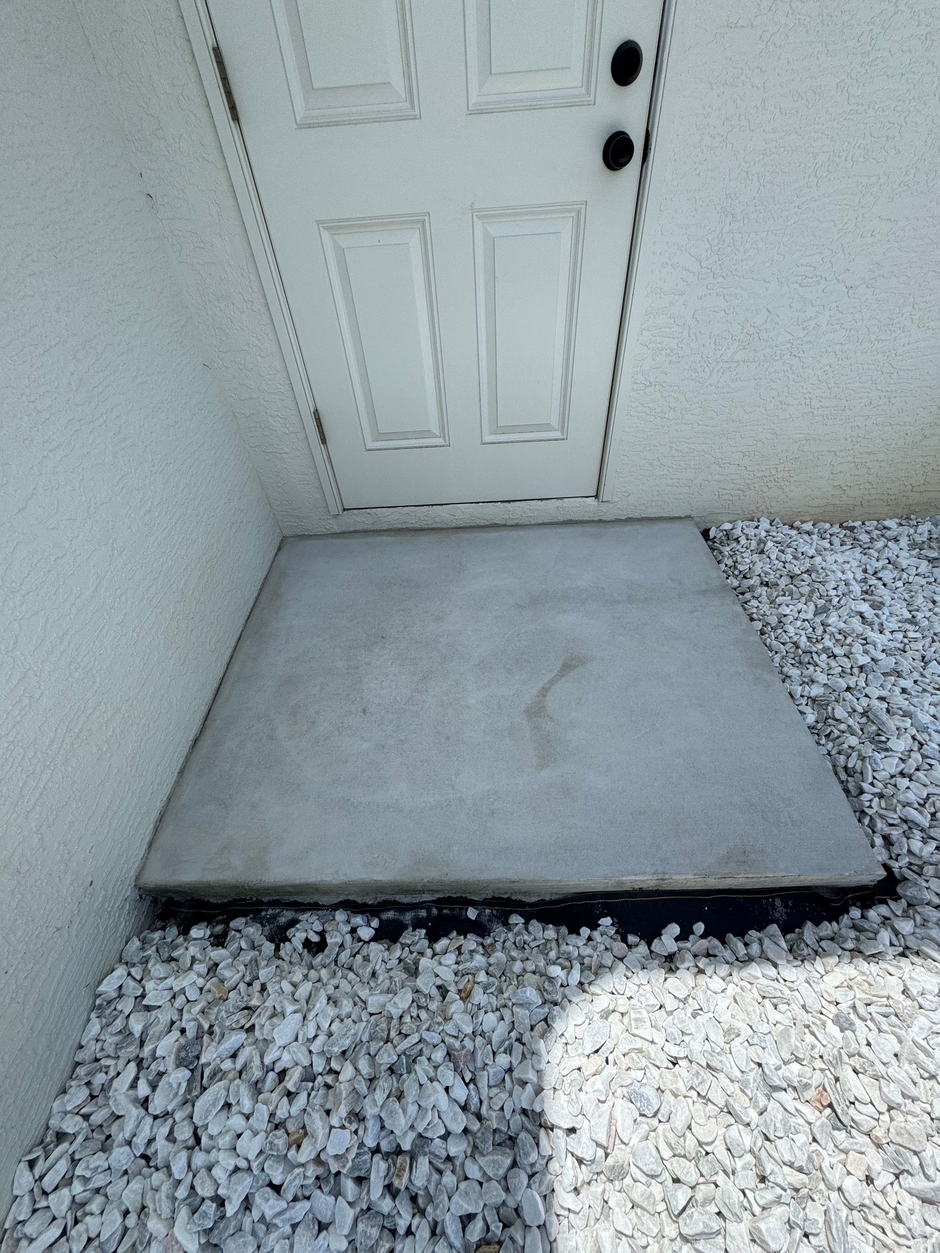 A white door with a concrete step in front of it