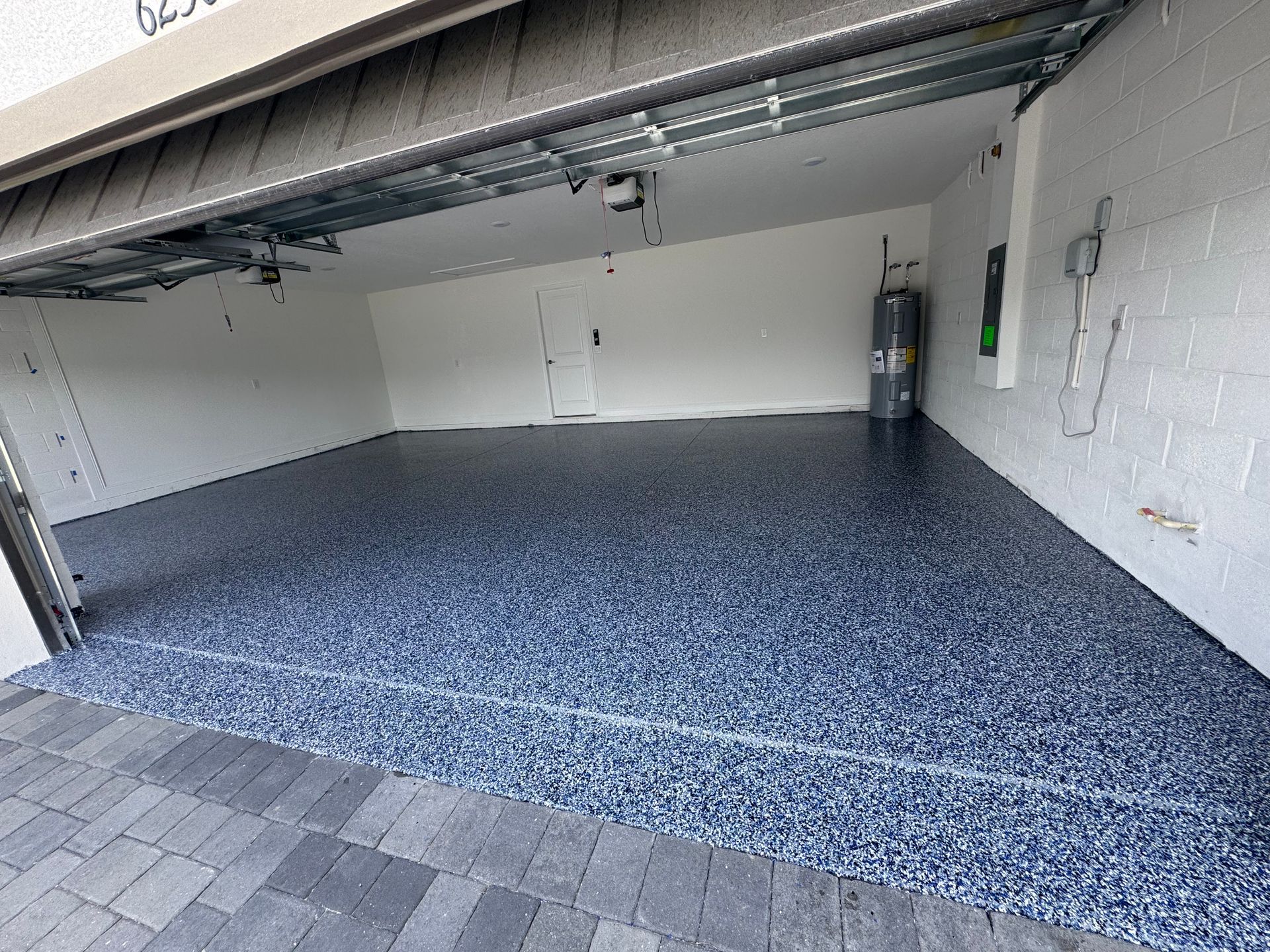 A garage with a blue floor and a white wall.
