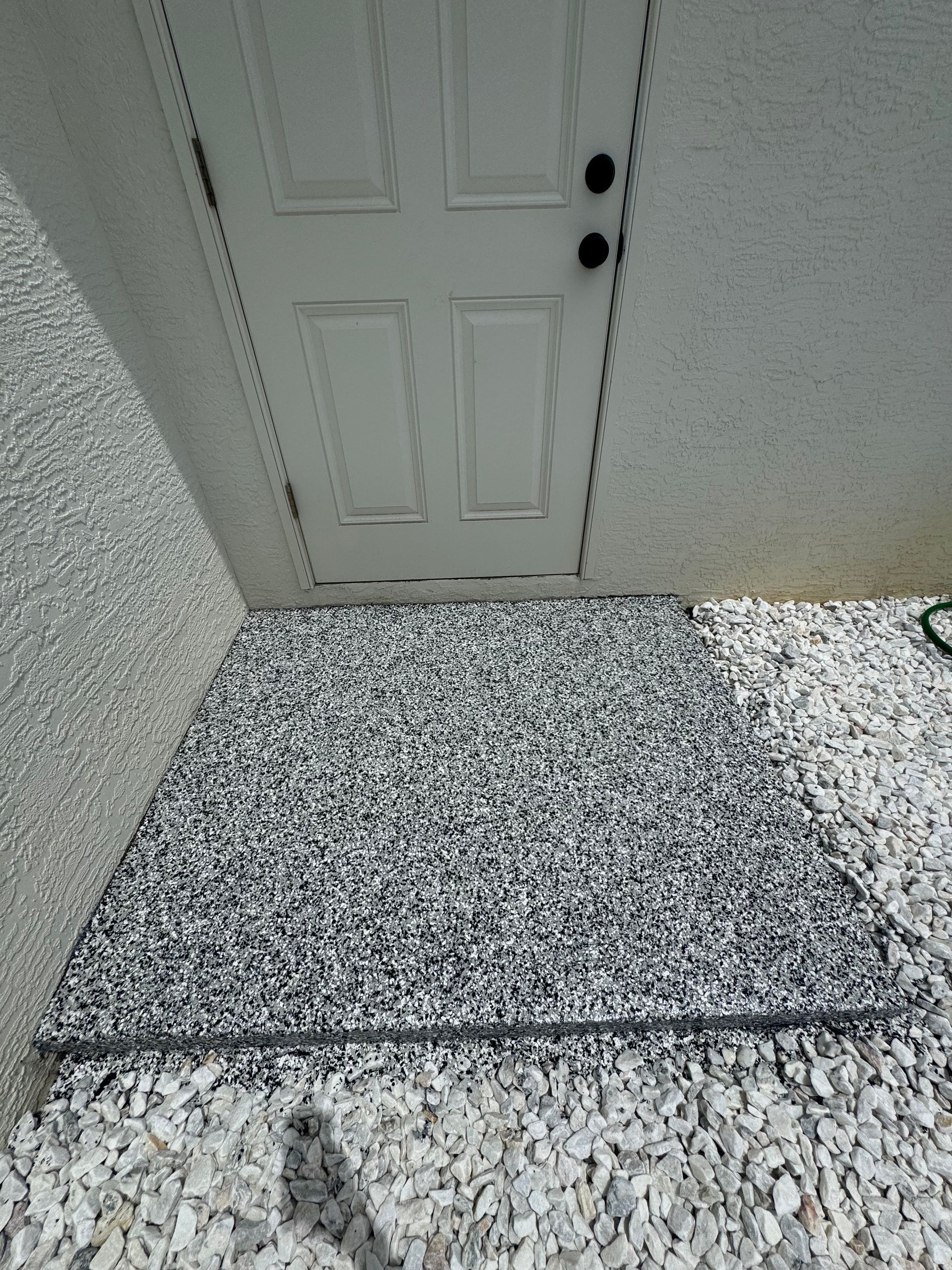A white door is sitting next to a pile of gravel.