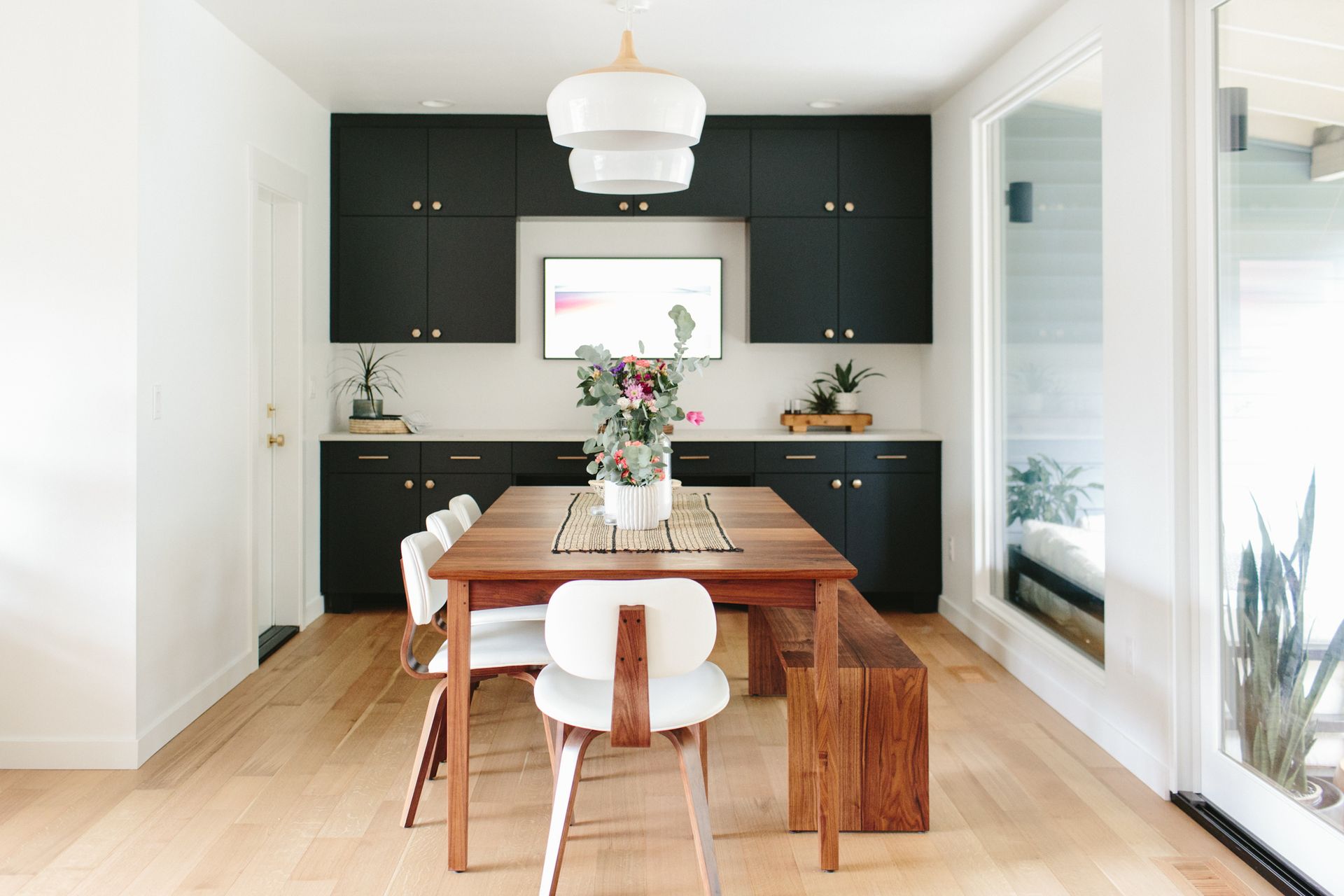 A dining room with a table and chairs and a bench