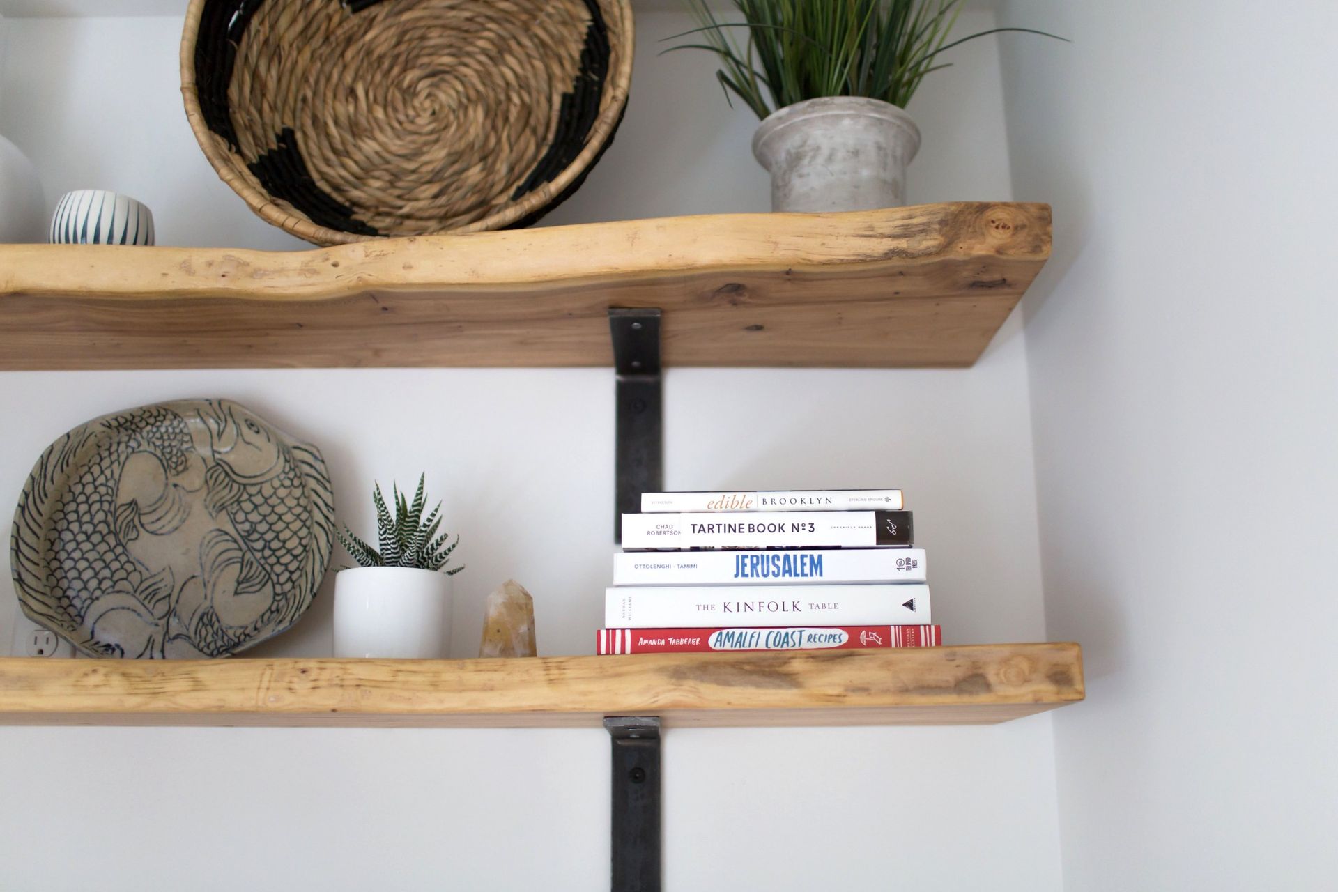 A wooden shelf with a stack of books on it.