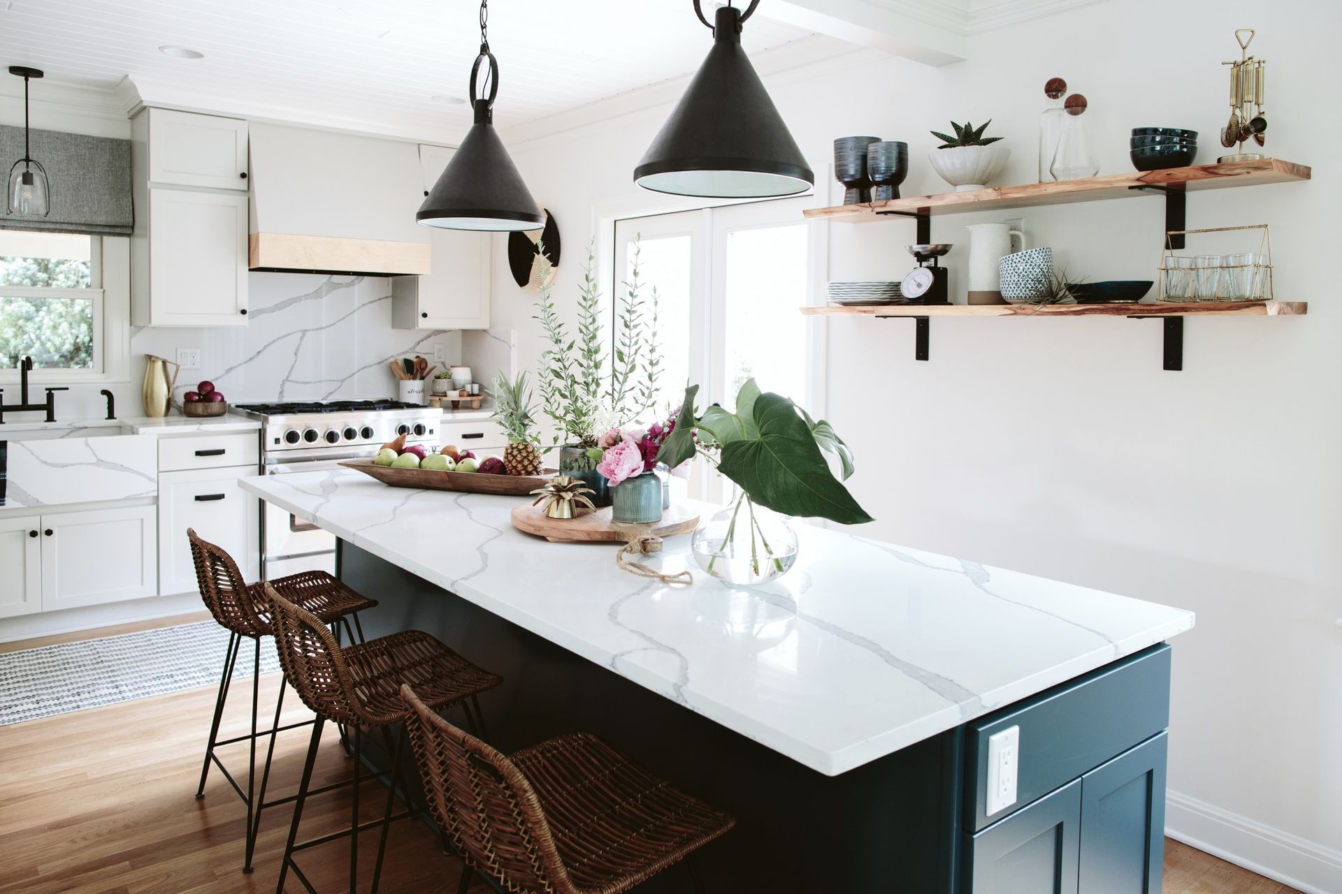 A kitchen with a large island and wicker stools
