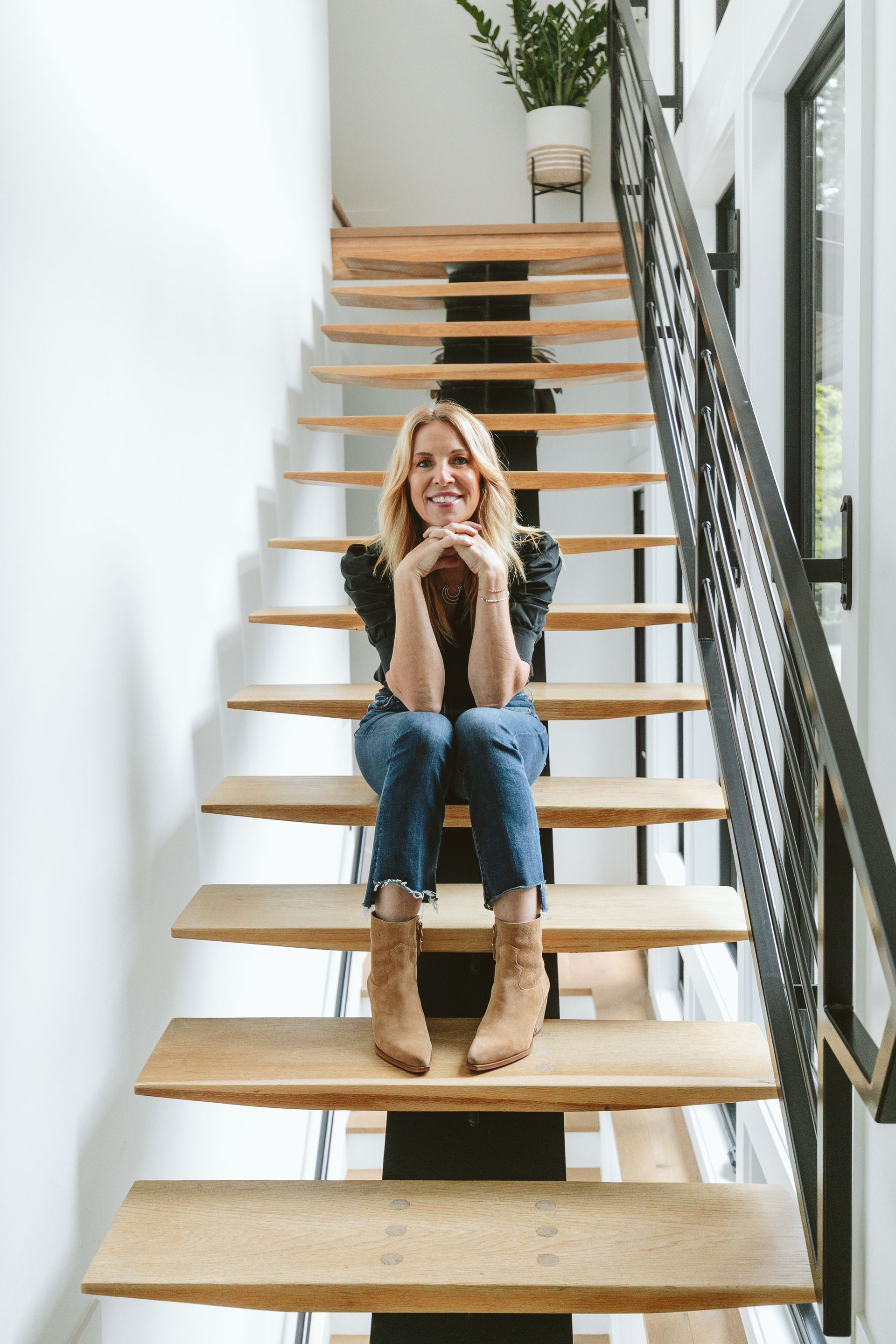 A woman is sitting on a set of wooden stairs.