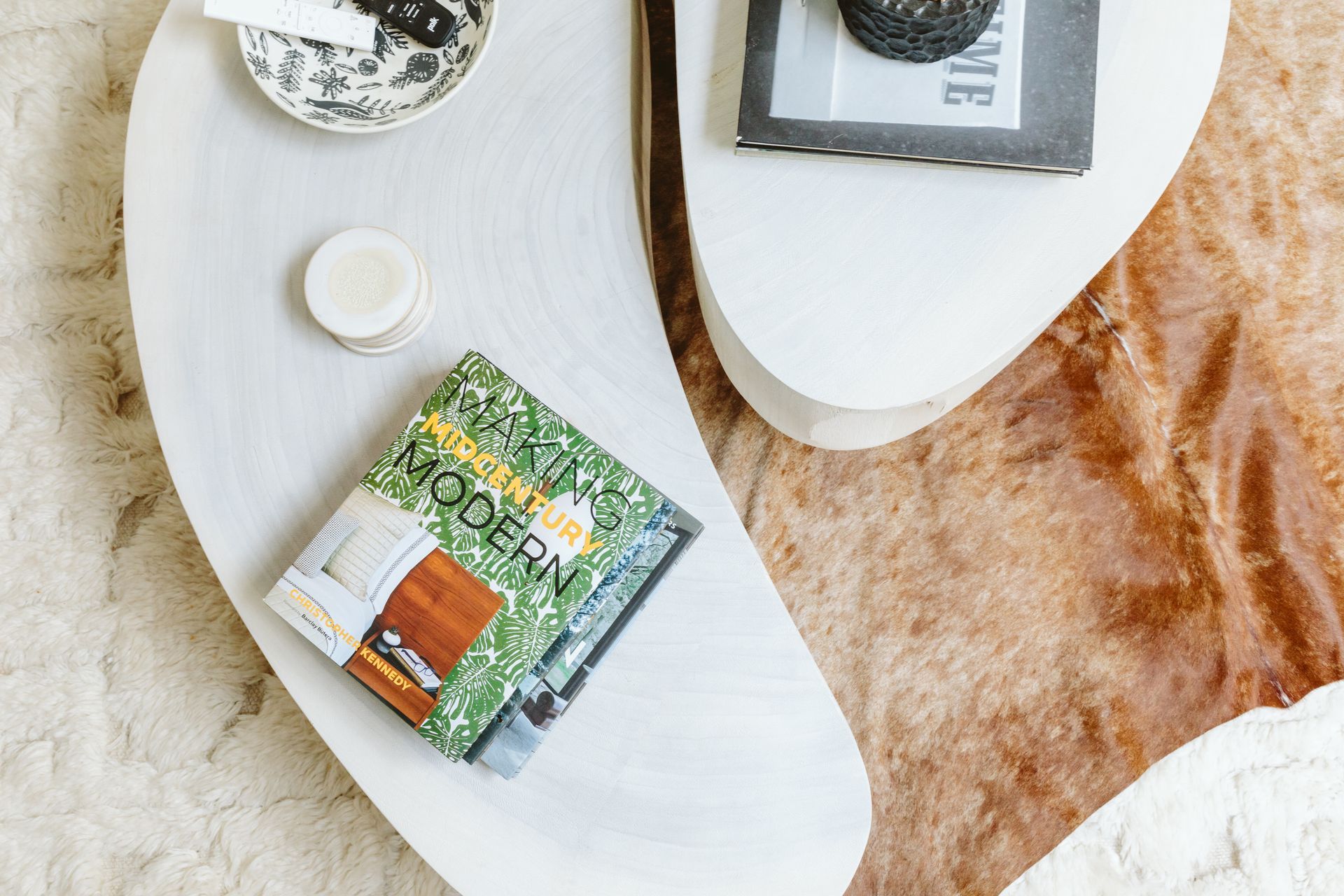 A book is sitting on top of a white coffee table.