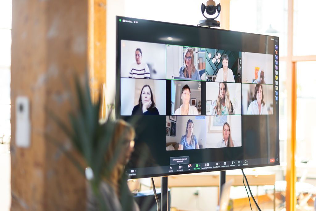 A group of people are having a video call on a large flat screen tv.