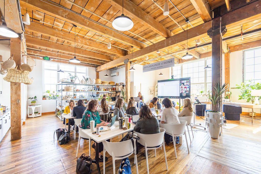 A group of people are sitting at tables in a large room.