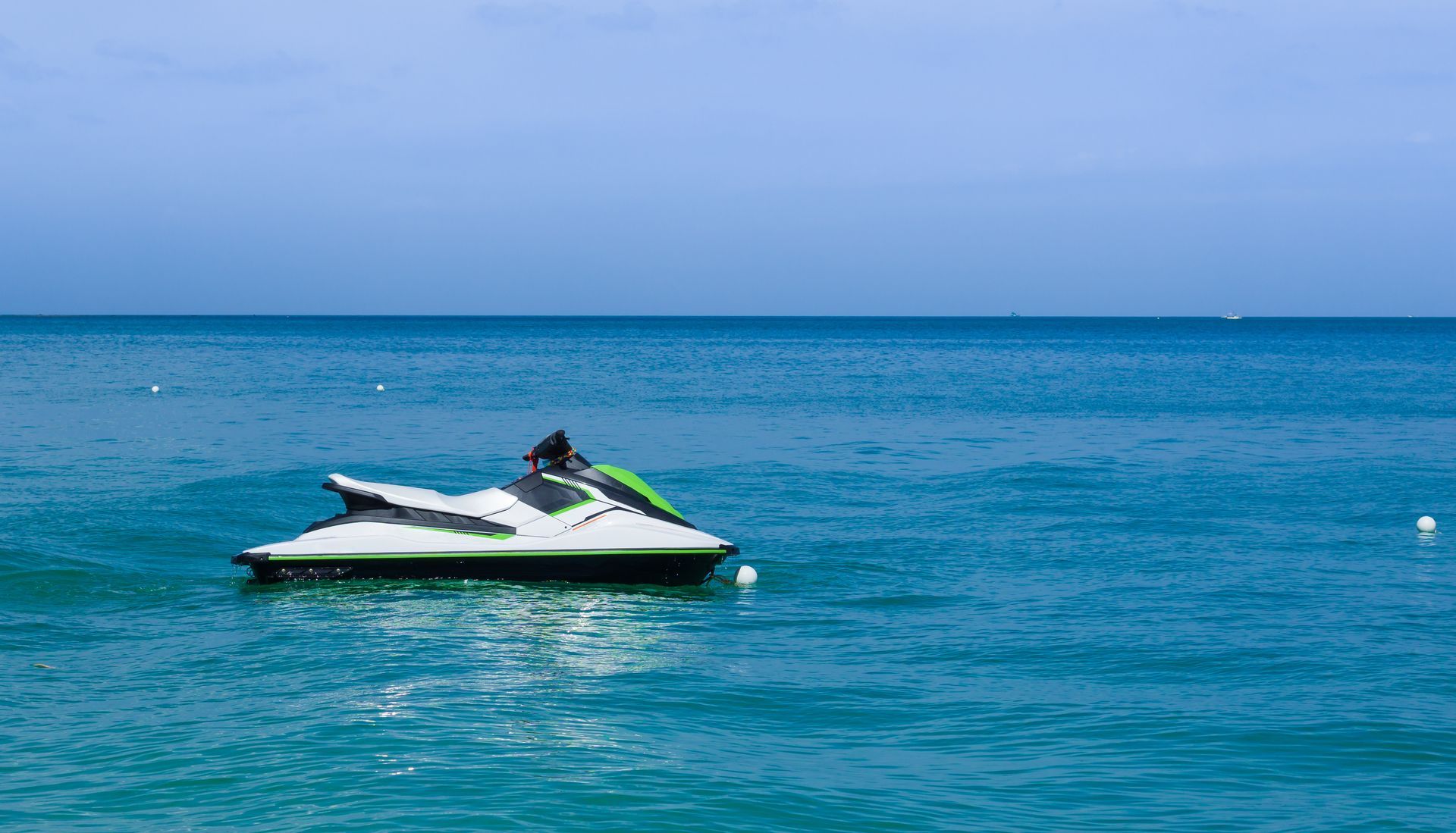 A jet ski is floating on top of a large body of water.