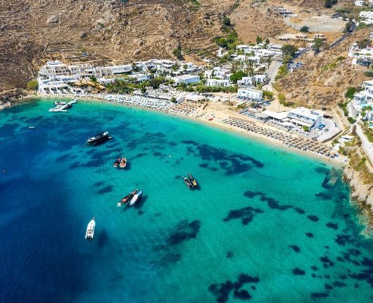 Sunlit Mykonos beach with turquoise water and white sand