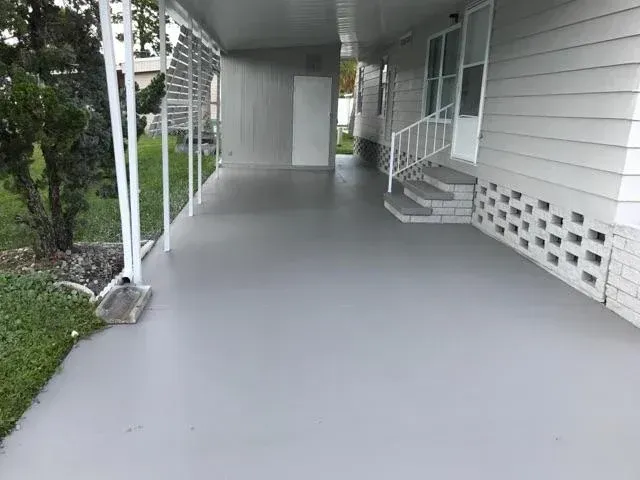A white house with a wooden deck in front of it