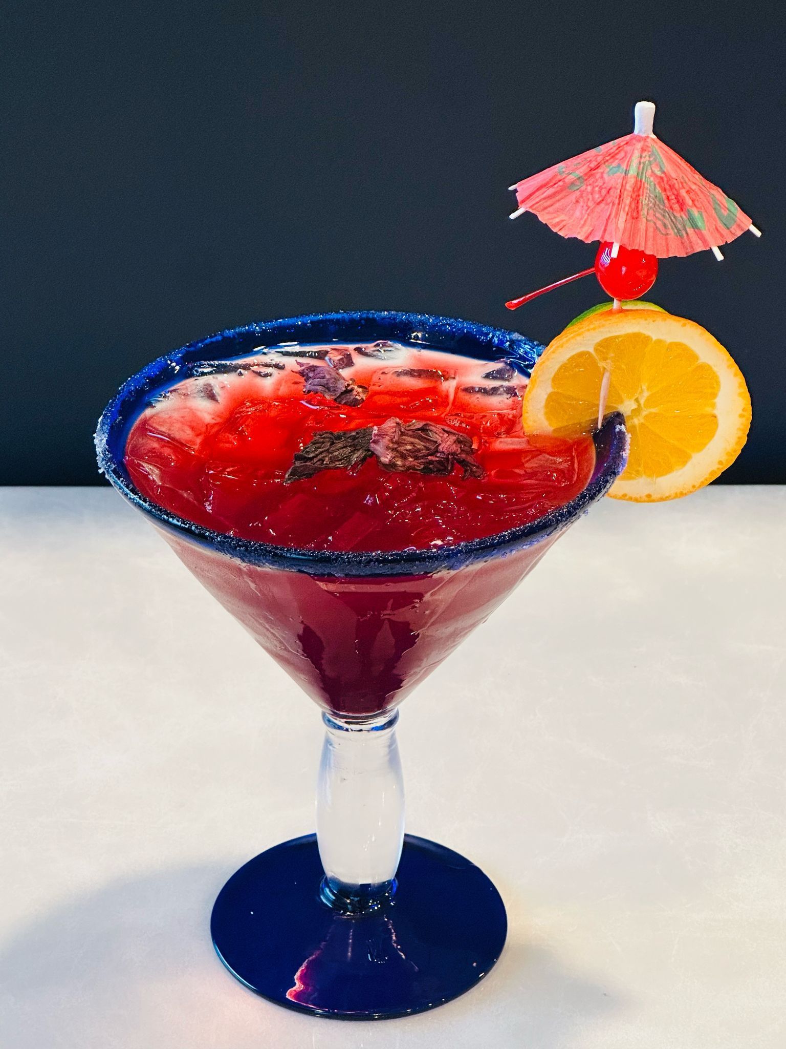 A martini with a pink umbrella on top of it