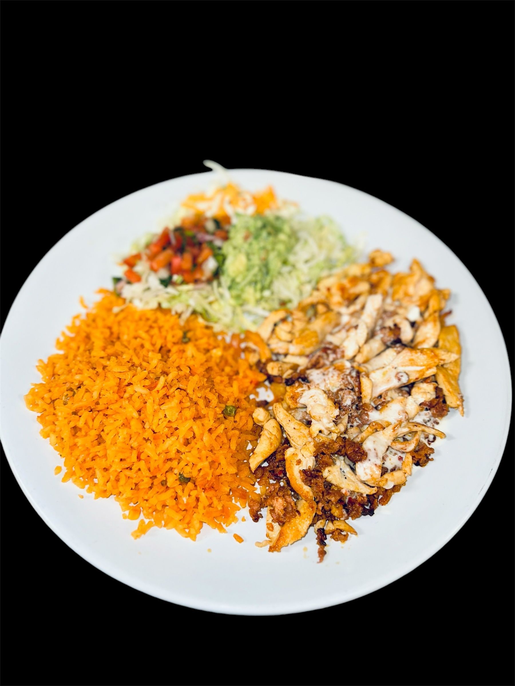 A white plate topped with rice and chicken on a black background.