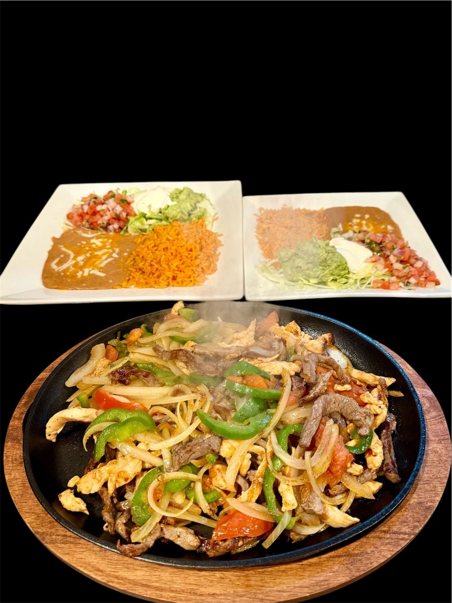 A plate of food is sitting on a wooden table next to two plates of food.