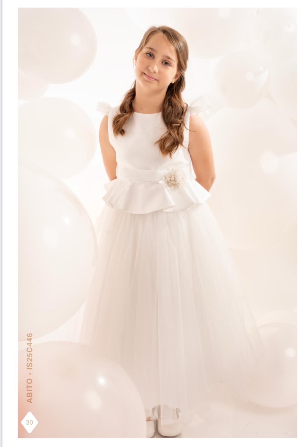 Ragazza in abito bianco circondata da palloncini bianchi.