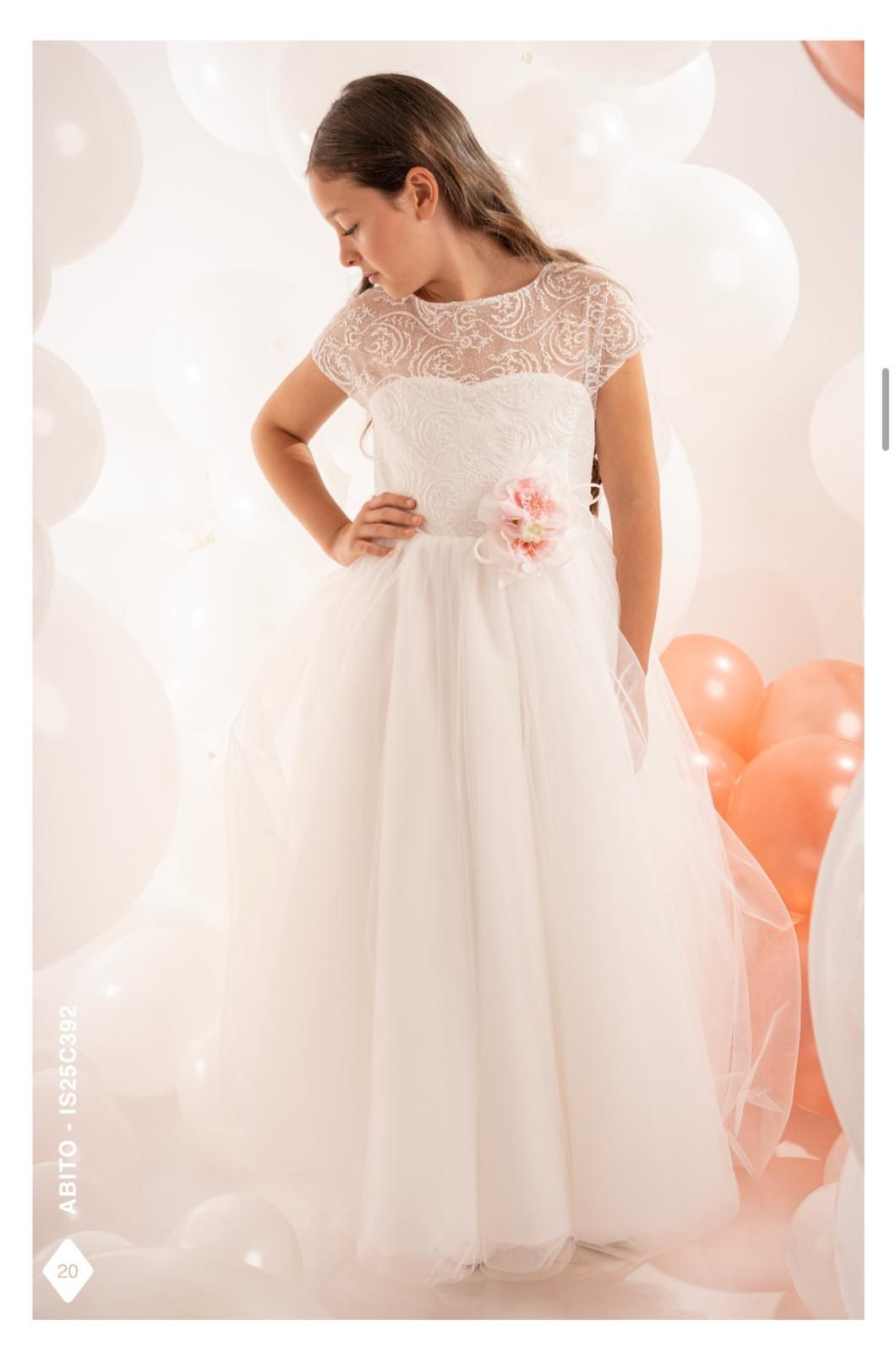 Ragazza con abito bianco e cintura floreale, che guarda in basso, circondata da palloncini.