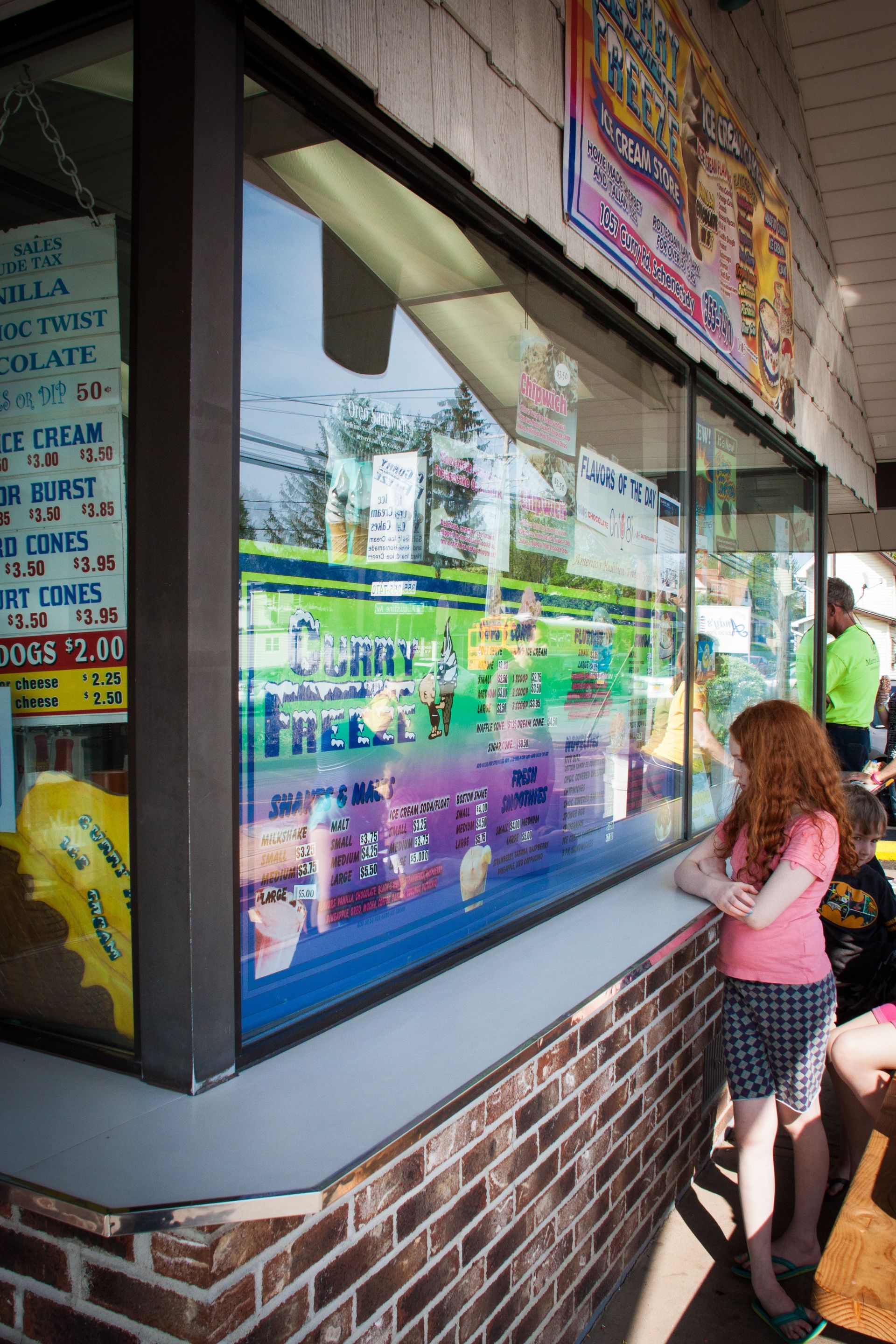 Young person looking in Curry Freeze window at the menu we offer.
Curry Freeze Ice Cream Shop