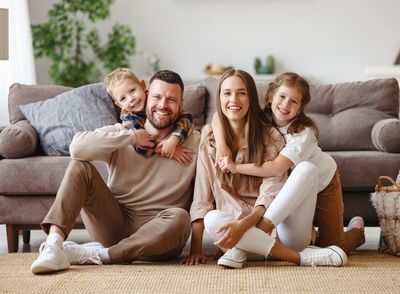 Happy family mother father and children at home on couch s