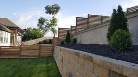 a backyard with a brick wall and a wooden fence