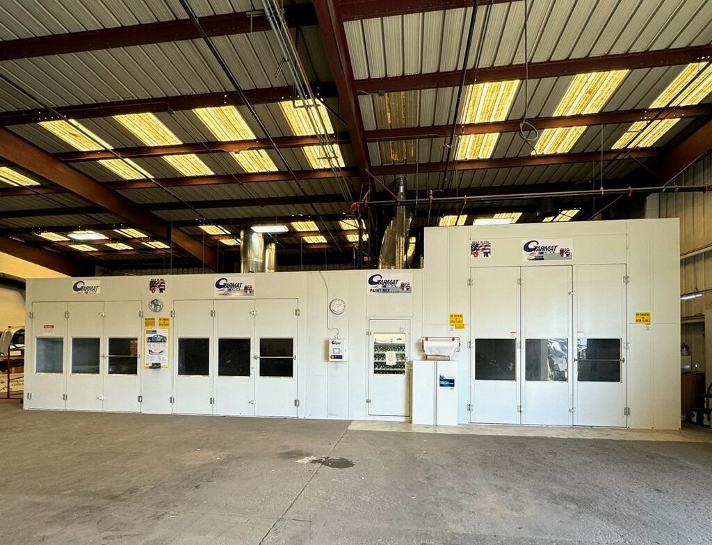 A large painting booth with a lot of doors and windows at Spectrum Auto Collision