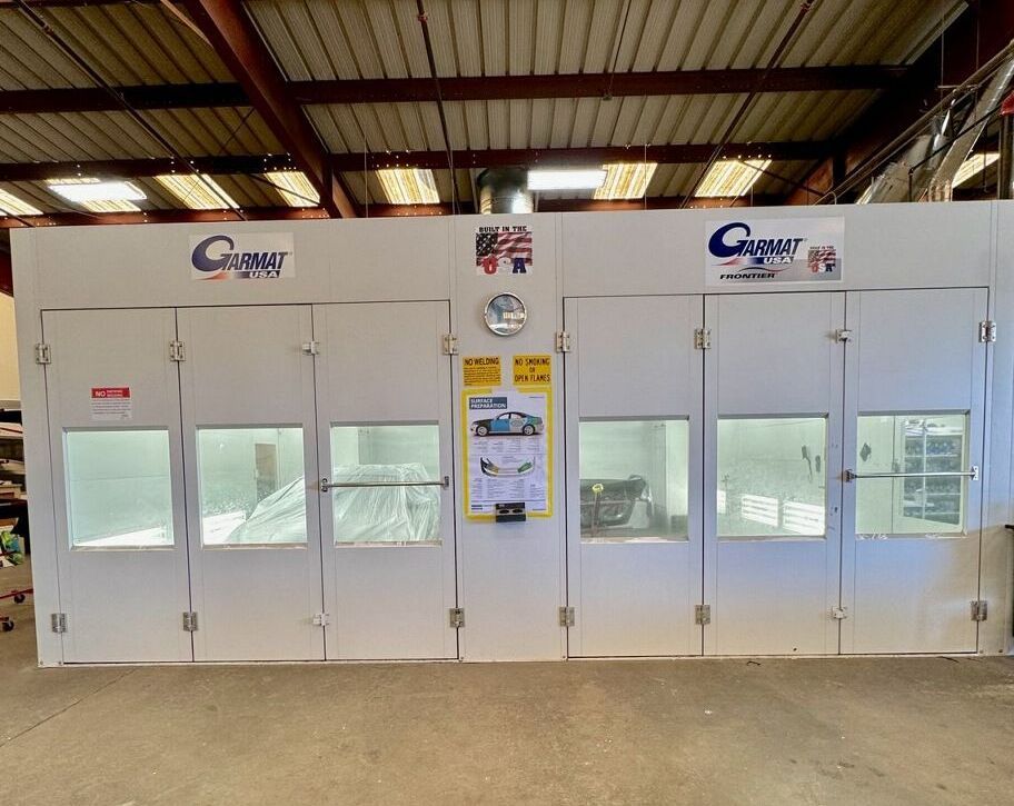 A Spectrum Auto Collision paint booth with a sign that says ' cougar ' on it