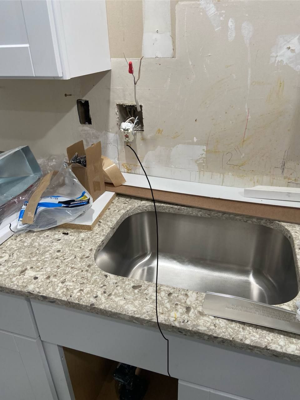 A stainless steel sink is sitting on top of a granite counter top.