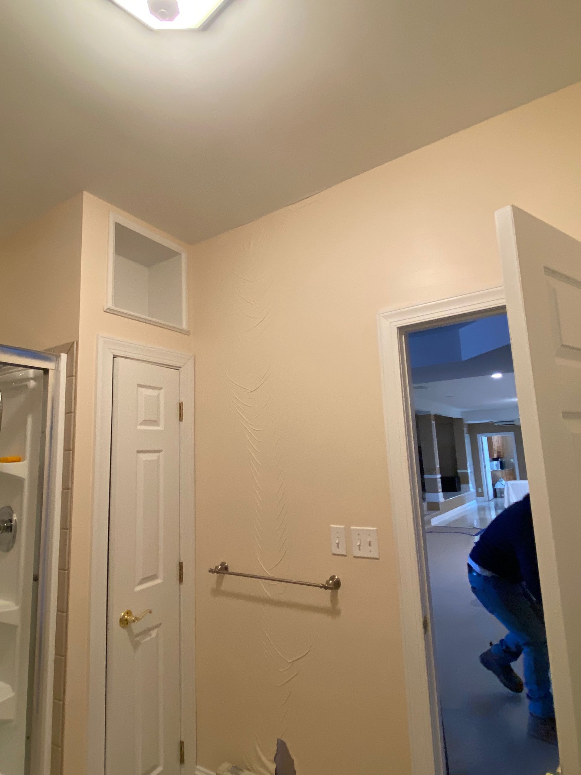 A bathroom with a white door and a towel rack