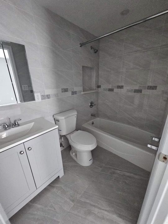 A bathroom with a toilet , sink and bathtub.