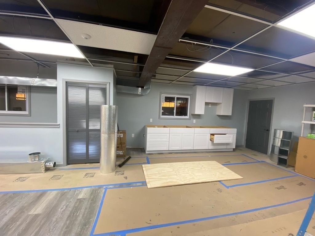 A kitchen under construction with a stainless steel refrigerator