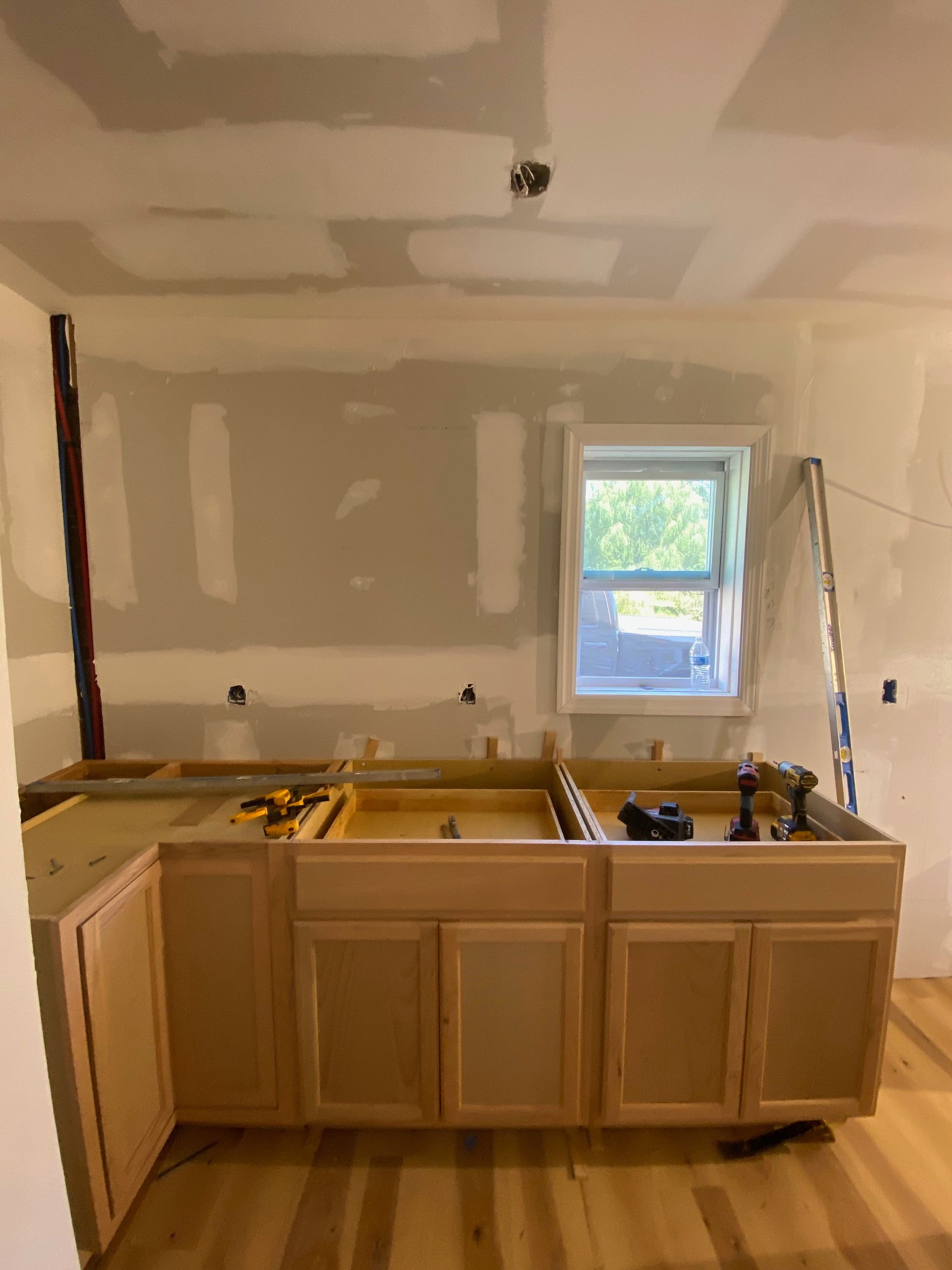 A kitchen under construction with a sink and cabinets