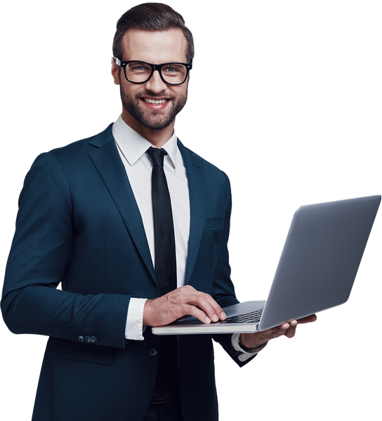Man in a dark suit, glasses, and tie, smiling while holding a laptop.