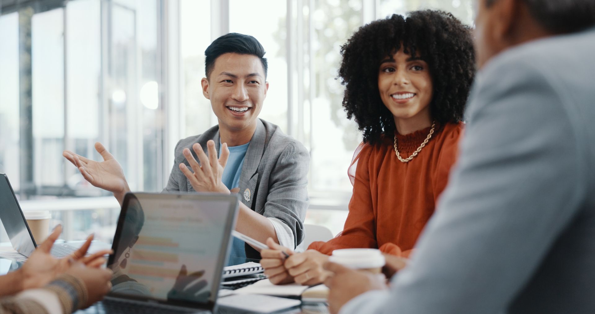 A group of people are sitting around a table having a meeting.