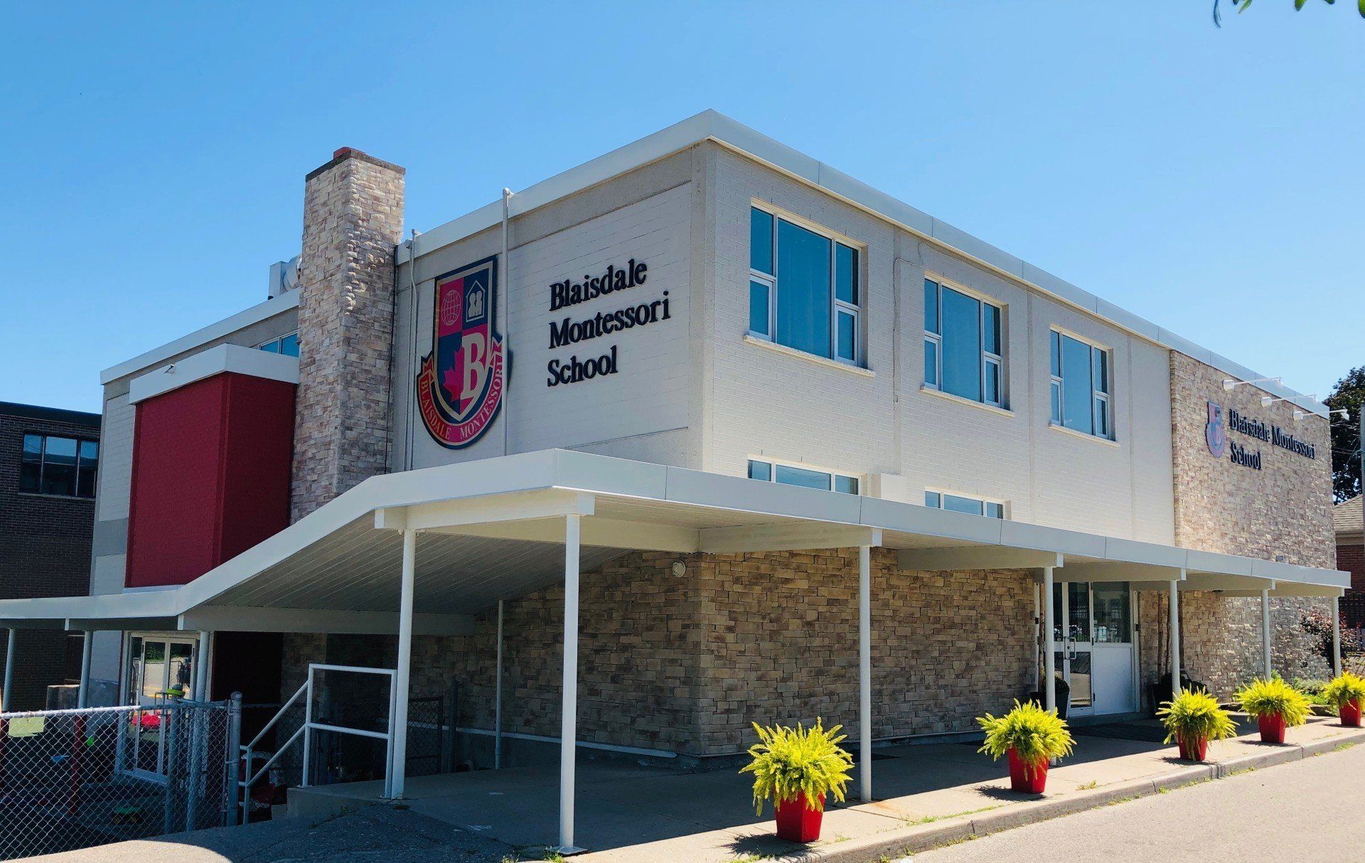 A large building with a canopy and a sign that says ' williamdale admission school ' on it.