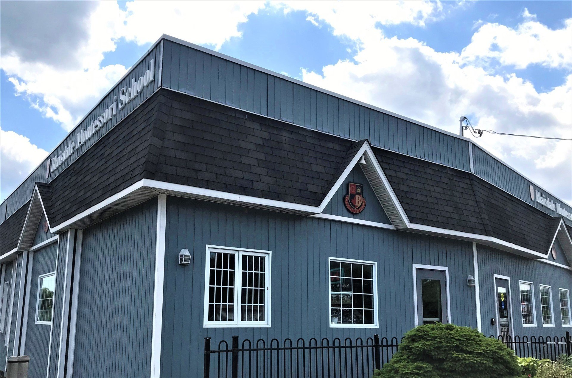 A blue building with a black roof and white windows